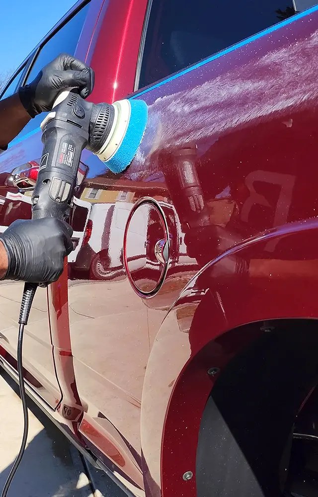 Vehicle paint being machine polished during a paint correction service